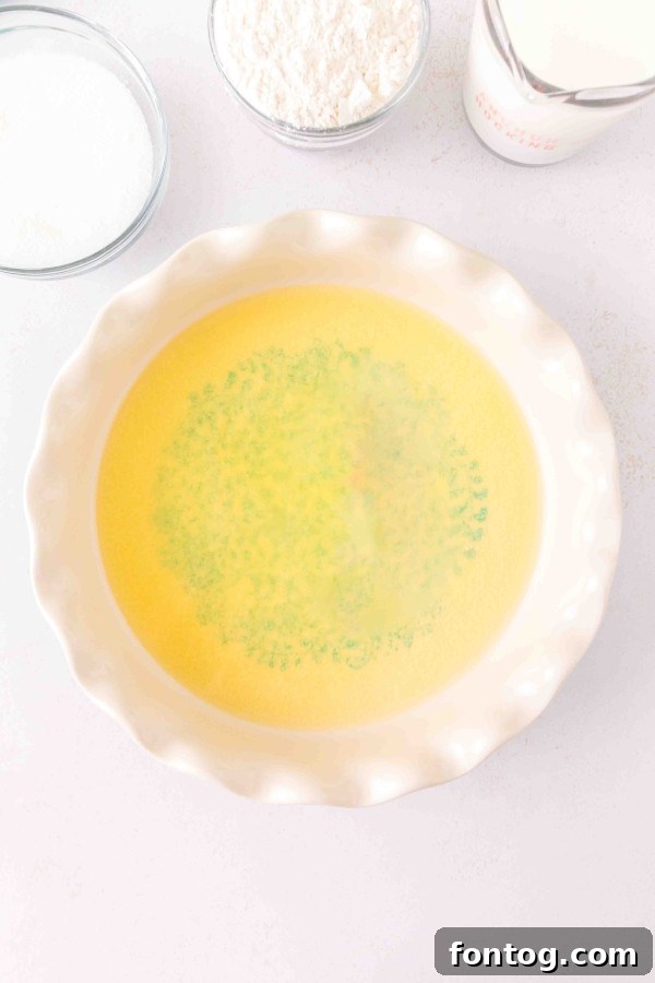 Melted butter in the bottom of a ceramic baking dish, ready for blackberries.