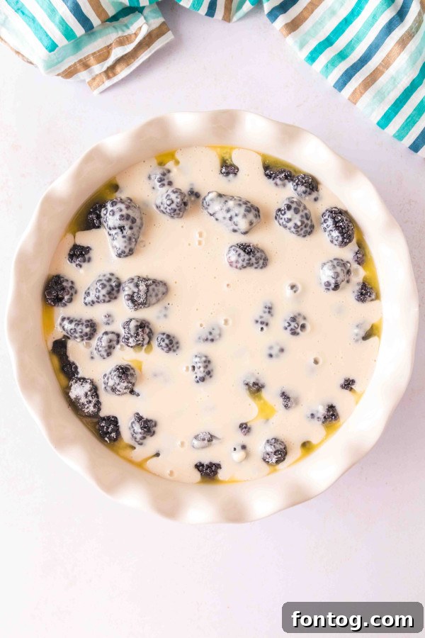 Blackberries placed over melted butter in a baking dish, before adding batter.