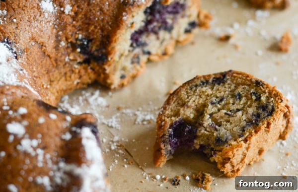 Close-up of a rustic slice of gluten-free blueberry bread, showing its texture