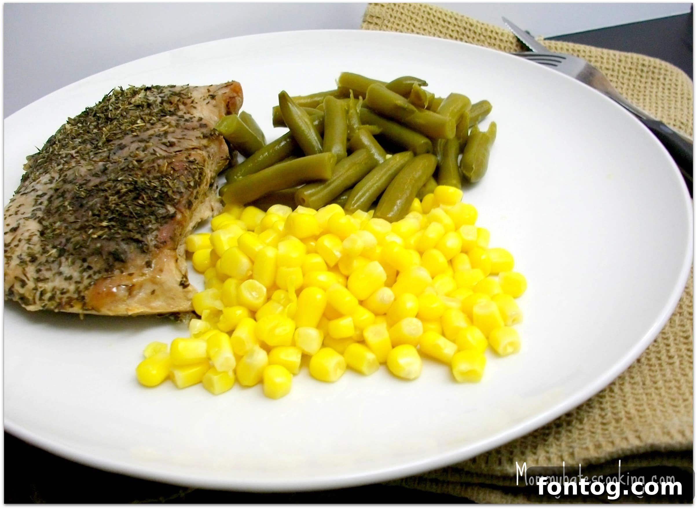 Delicious Apple Seasoned Pork Chops ready to eat, garnished with fresh herbs.