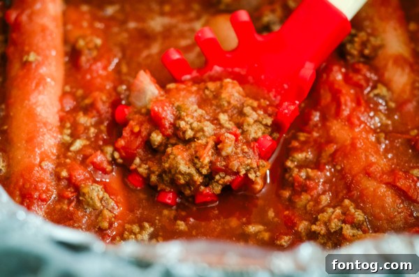 Assorted toppings for chili dogs including cheese, onions, and sauce