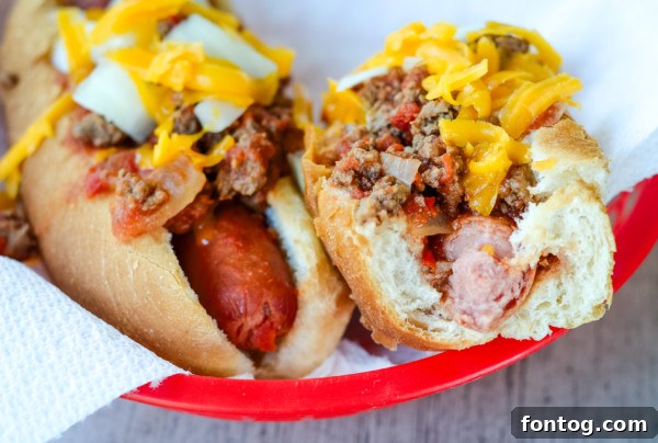 A serving of slow cooker chili dogs on a wooden board