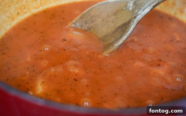 Close-up of a spoonful of creamy tomato florentine soup.