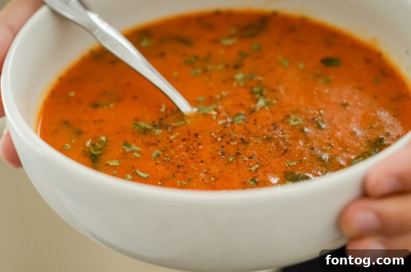 A pot of creamy tomato florentine soup simmering on the stove.