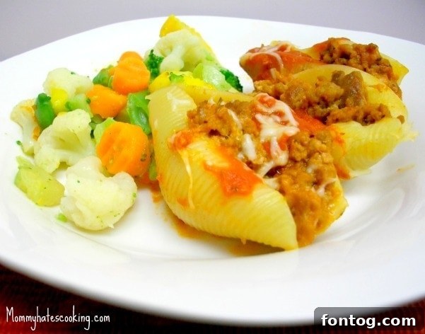 A side view of the Stuffed Beef Shells casserole, showing the rich filling and melted cheese, served with a simple side of steamed green vegetables.
