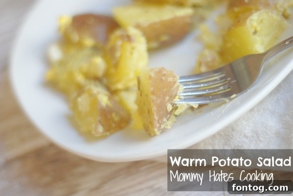 Close-up of Warm Potato Salad featuring hard-boiled eggs and fresh herbs, ready for serving