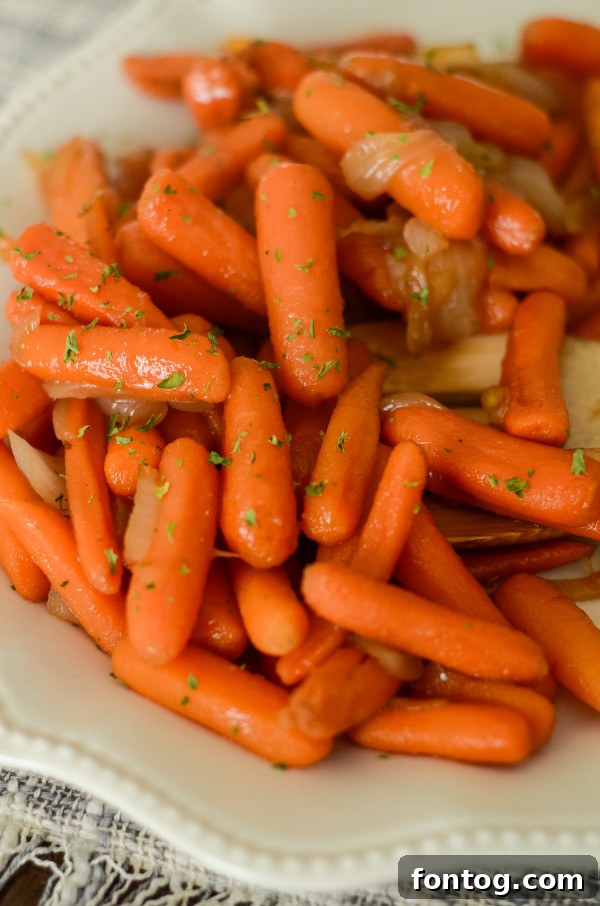 Beautifully plated Apple Cider Glazed Carrots, glistening with a sweet brown sugar and apple cider glaze, ready to serve as a festive side dish.