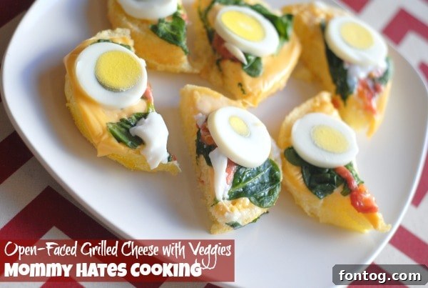 Two perfectly toasted open-faced grilled cheese sandwiches with melted cheese and fresh vegetables.