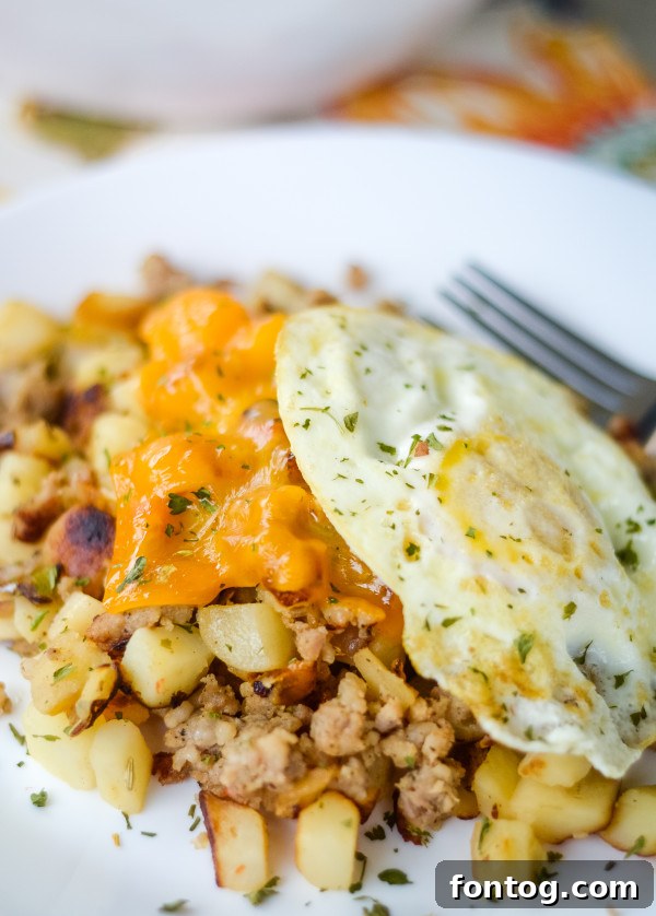 Savory Sausage, Egg, and Cheese Breakfast Hash 2 Delicious Cheesy Sausage and Egg Hash served hot in a skillet