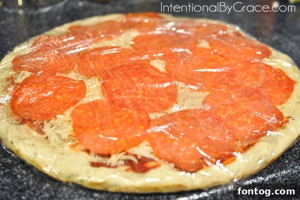 Homemade frozen pizza wrapped in plastic