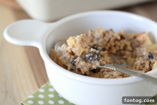Apple Pie Spiced Baked Oats 6 Close-up of baked apple cinnamon steel cut oats being scooped from a baking dish, ready for serving.