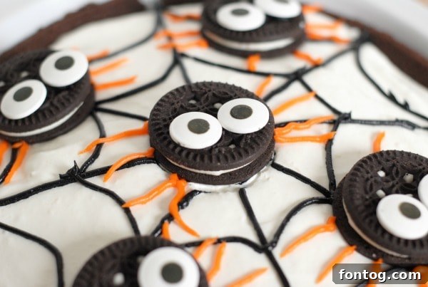 Delicious No-Bake Spider Pudding Pie topped with a spooky spiderweb and chocolate cookie spiders