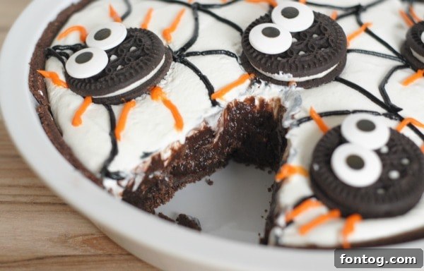 A tantalizing slice of No-Bake Spider Pudding Pie showcasing its rich chocolate pudding and fluffy whipped topping layers