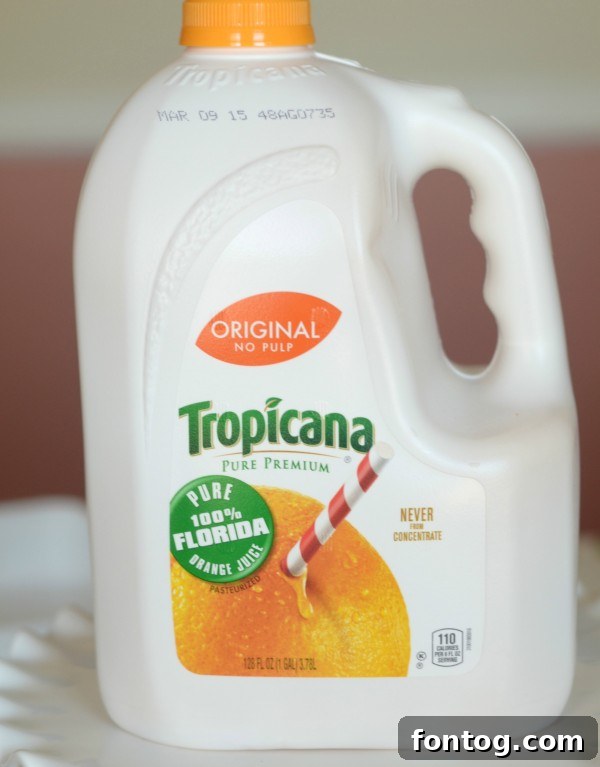 Effortless Party Breakfasts: Berry Orange Smoothies and More 12 A close-up of a rustic pitcher filled with orange juice, highlighting the freshness of the drink, an essential part of a healthy and delicious brunch.