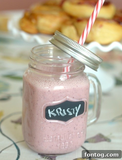 Effortless Party Breakfasts: Berry Orange Smoothies and More 14 A vibrant Berry Orange Smoothie in a glass, garnished with fresh berries, showcasing a healthy and refreshing drink option for breakfast or brunch.