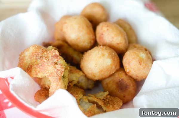 Savannah Classics Sweet Corn Hush Puppies and Catfish Nuggets, served family-style on a picnic table with checkered placemats.
