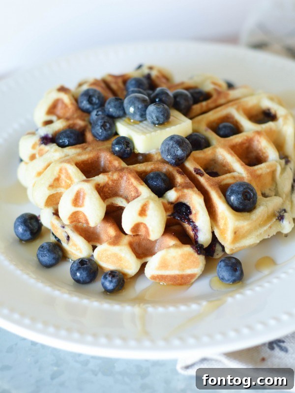 Fluffy Gluten-Free Blueberry Waffles with fresh blueberries and syrup