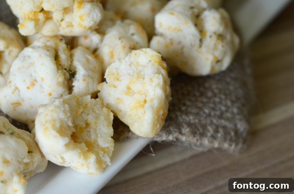 A bowl of gluten-free cheddar bay biscuits ready to be served with a meal.