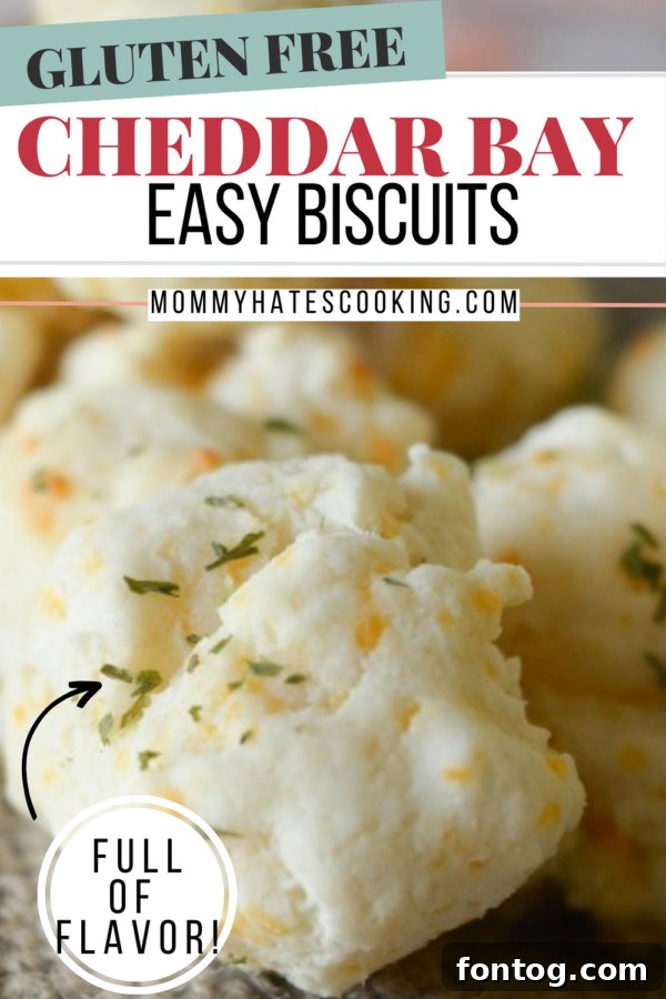 Stacked gluten-free cheddar bay biscuits with a side of fresh herbs, ready to be enjoyed.