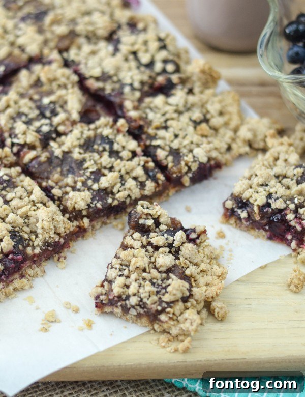 Freshly baked blueberry oatmeal breakfast bars on a cooling rack, showcasing a golden crust and juicy blueberry filling.