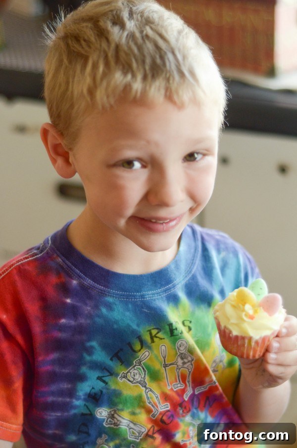 Fresh Bloom Cupcakes 11 A young boy proudly presenting a tray of freshly baked and meticulously decorated Spring Cupcakes, beaming with accomplishment.