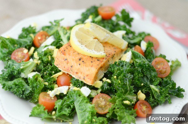 Finished Lemon Tossed Kale Salad with Salmon on a white plate, ready to serve