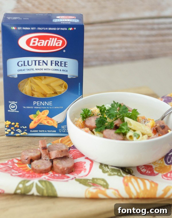 Close-up of a serving of Chicken & Apple Sausage Pasta Bowls, showing pasta, sausage slices, and colorful bell peppers