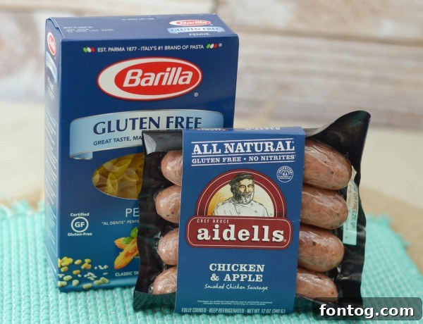 Ingredients for Chicken & Apple Sausage Pasta Bowls laid out, including pasta, sausage, peppers, and cream cheese