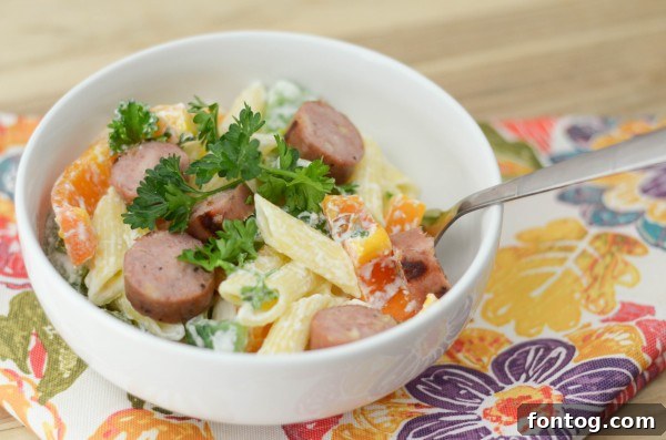 Individual serving of Chicken & Apple Sausage Pasta Bowl, garnished with fresh parsley