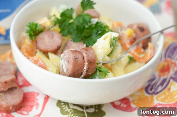 Another perspective of the Chicken & Apple Sausage Pasta Bowls, highlighting the creamy sauce and colorful vegetables