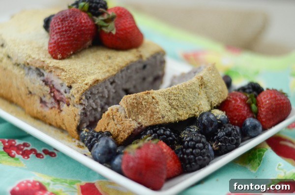 A whole loaf of golden-brown Berry Oatmeal Bread, garnished with a sprinkle of oats on top.