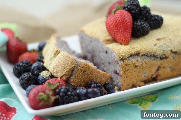 Individual serving of Berry Oatmeal Bread on a rustic cutting board, surrounded by fresh berries.