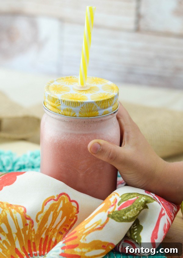 A glass of Watermelon Smoothie garnished with a fresh watermelon slice