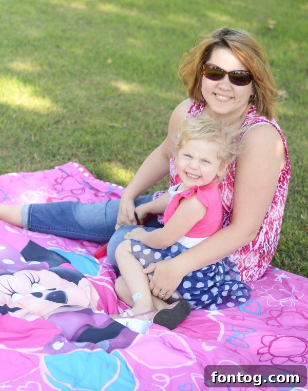 A little girl in a Minnie Mouse dress reaching for bubbles during an outdoor play session. #ChildhoodJoy #MinnieMouseFan