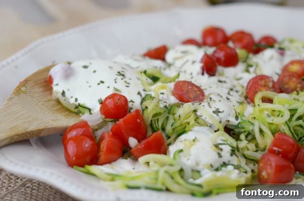 Cheesy Baked Zoodles mixed with tomatoes and onions