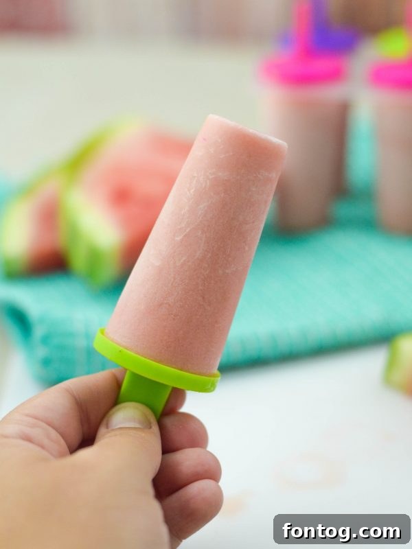 Several Watermelon Yogurt Pops lined up, showcasing their refreshing texture and inviting colors.