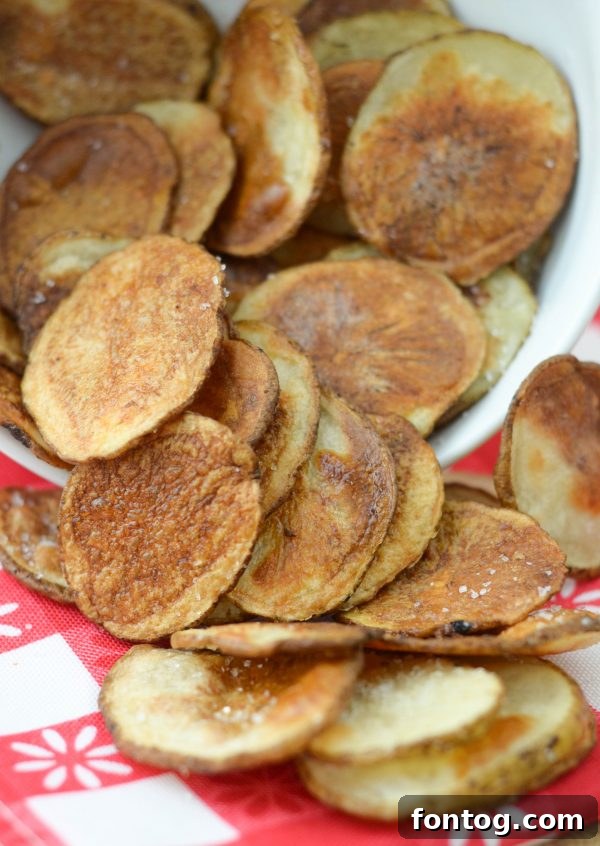 A baking sheet filled with seasoned potato slices, ready for the oven