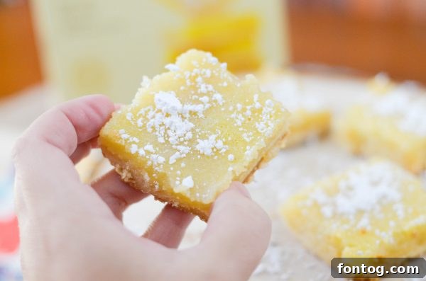 A slice of Old Fashioned Lemon Bar showing the buttery crust and lemon filling