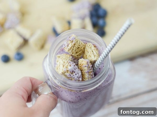 Happy child enjoying a Blueberry Wheat-fuls Smoothie on the go