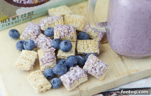 Glass of Blueberry Wheat-fuls Smoothie with ingredients in background
