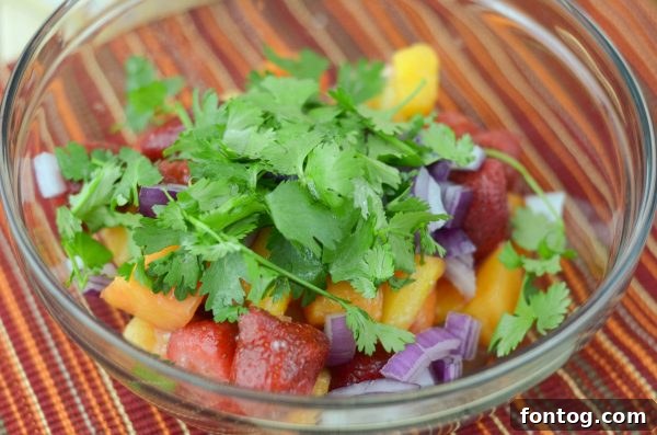 Mixing the Tropical Fruit Salsa with red onion and cilantro