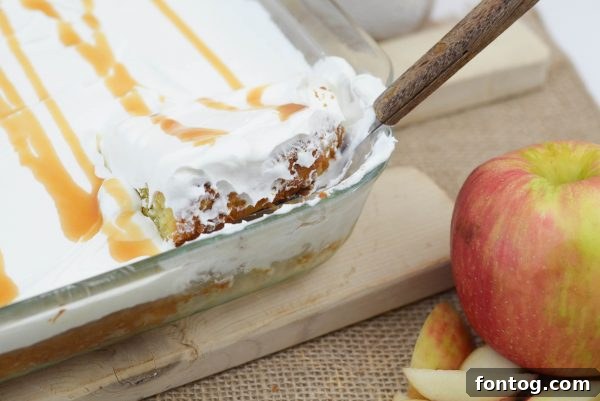 Close-up of a slice of Caramel Apple Cake with whipped topping