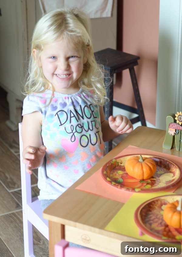A close-up of a child coloring on a paper placemat at a Thanksgiving kids' table setup.