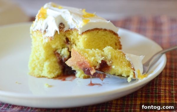 A close-up of a plated slice of Strawberry Jalapeño Cream Cheese Poke Cake
