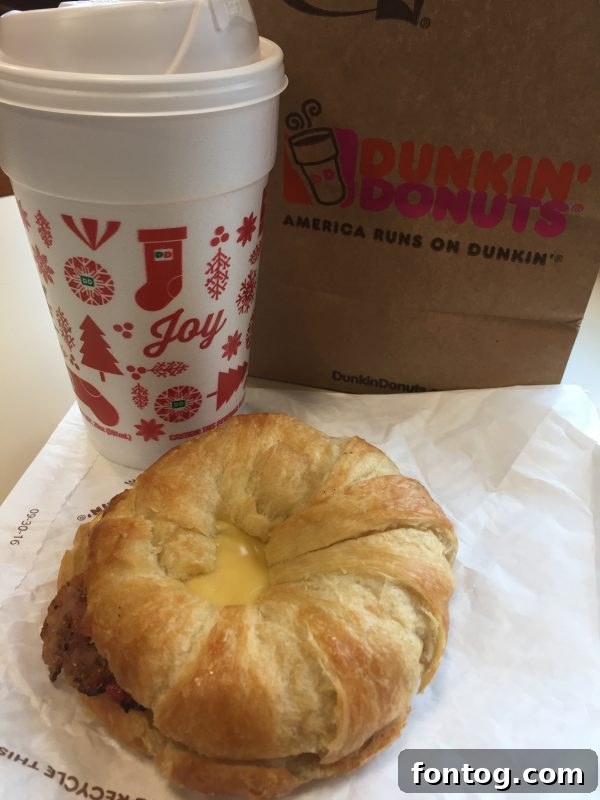 Close-up of a Dunkin' Sweet Black Pepper Bacon Breakfast Sandwich, showing its delicious layers