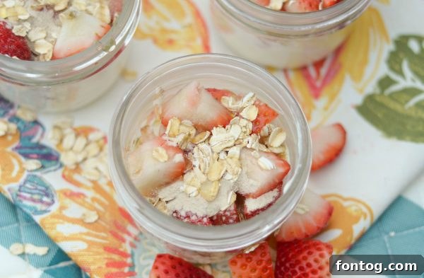 Prepared strawberry smoothie parfaits in mason jars, ready to blend. Ideal for quick meal prep and healthy breakfasts on the go.