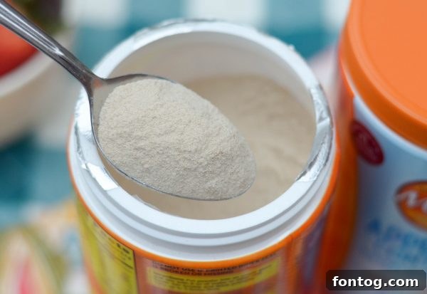 Two prep-ahead strawberry smoothies in mason jars with Meta powder visible on top, showcasing a healthy breakfast solution.