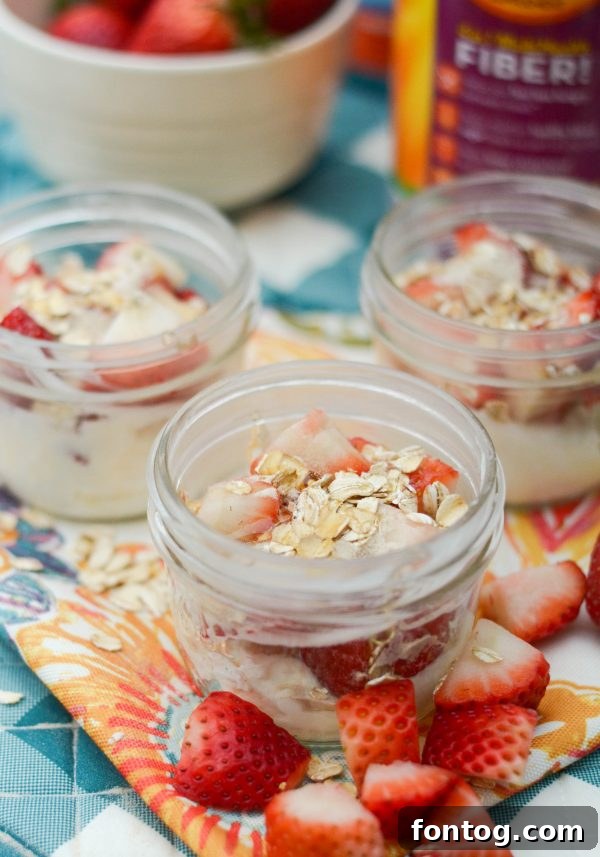 Pouring a prep-ahead strawberry smoothie from a mason jar into a blender. Illustrates the ease of use for these healthy, quick meals.