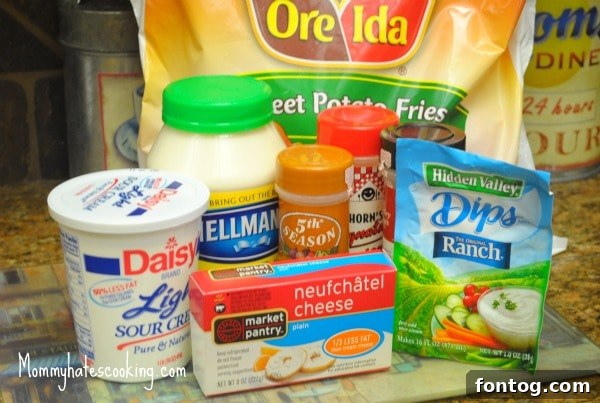 Various ingredients laid out for making creamy ranch dip, including mayo, sour cream, and cream cheese.