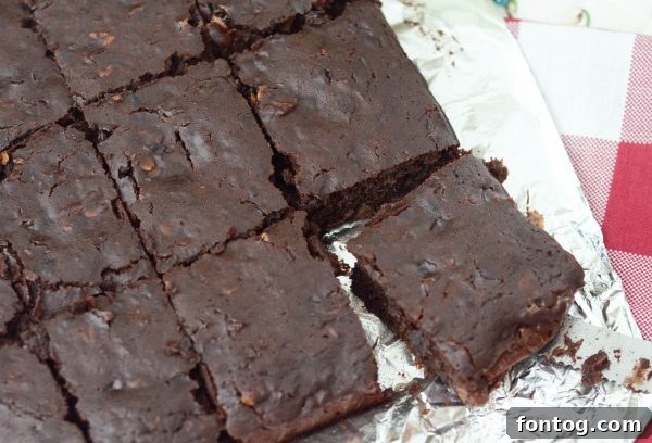 Black Bean Brownies - a close-up of a square brownie with chocolate chips on a white surface